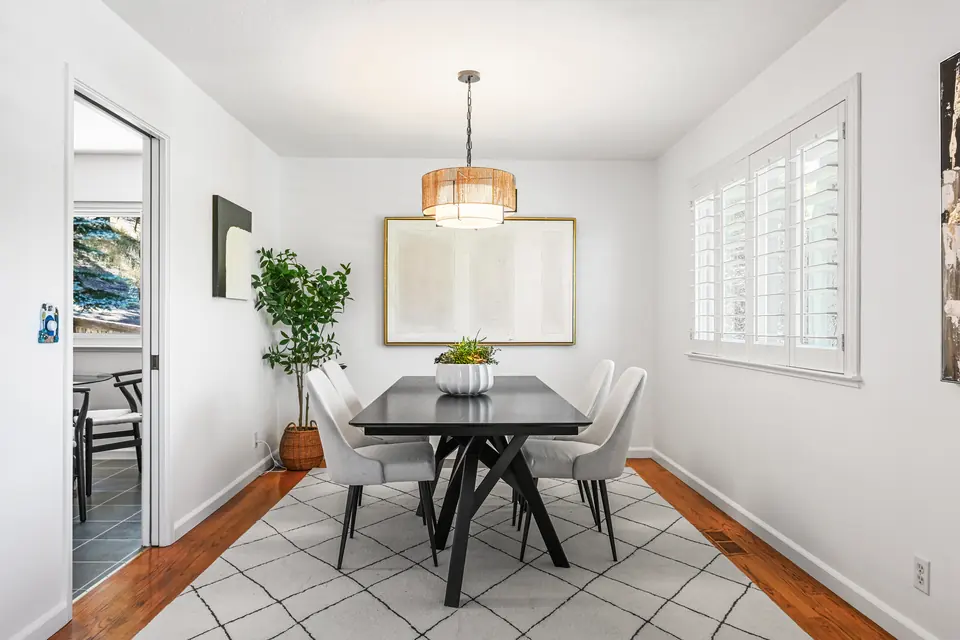 Dining room with a drum pendant and plantation shutters