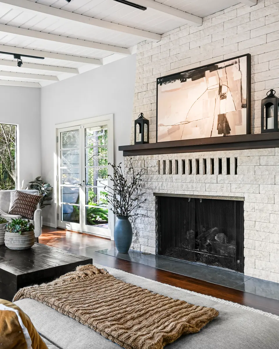 Living room with a white brick fireplace and a beamed ceiling